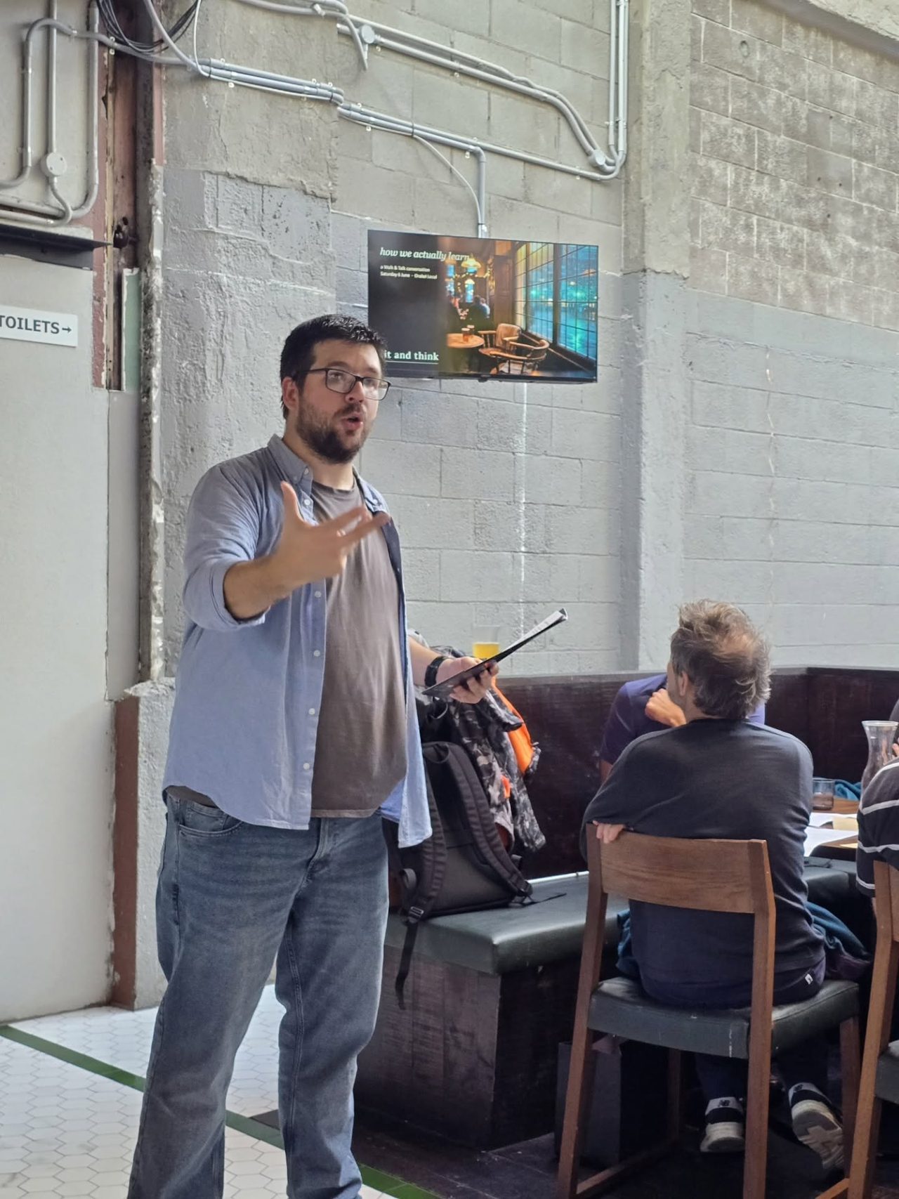 Dr Dmitry Zavialov mid-sentence, questioning a seated group during a session