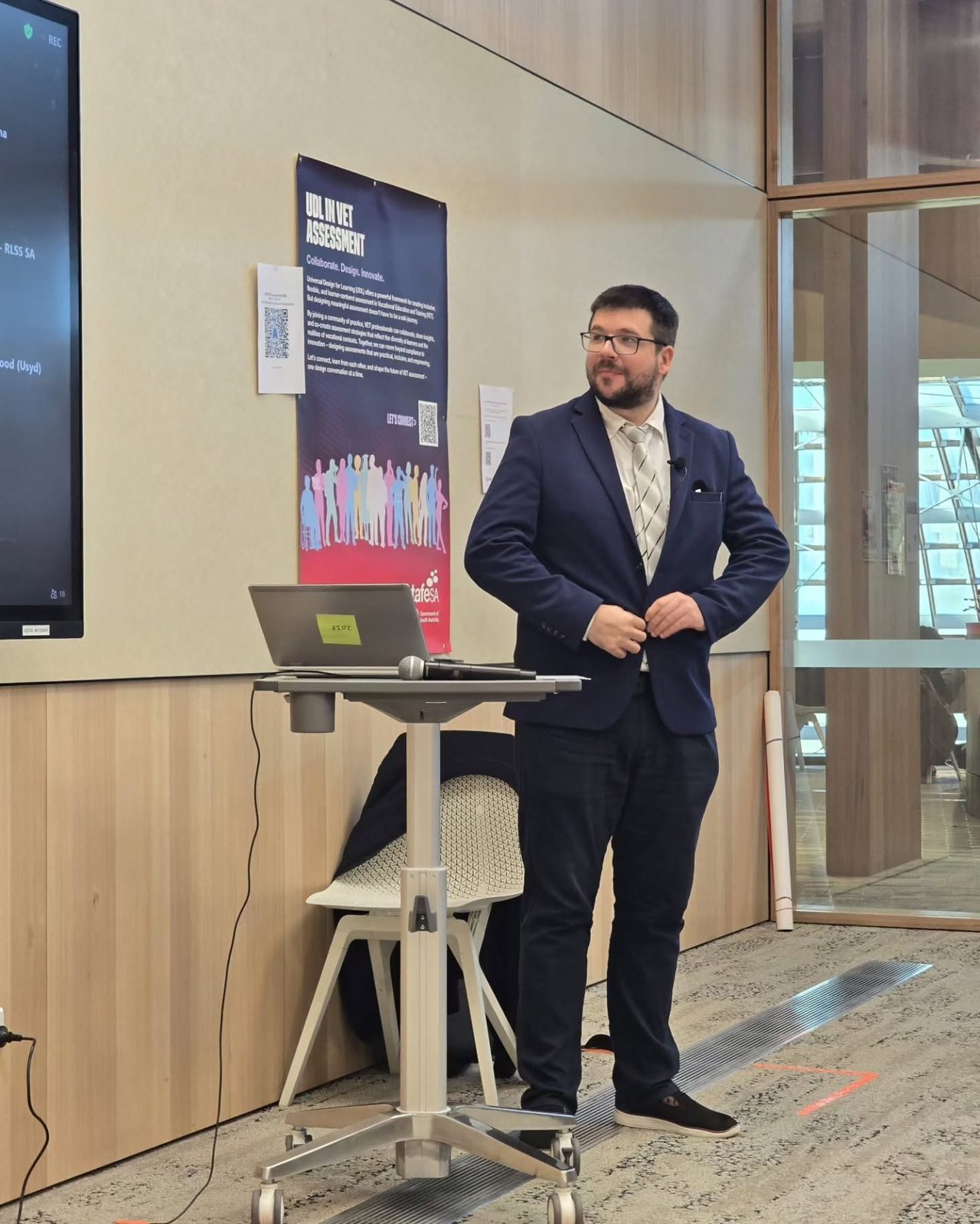 Dr Dmitry Zavialov in a navy suit, presenting at the ADCET Universal Design for Learning Symposium